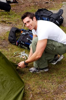 A man setting up a tent on a camping trip