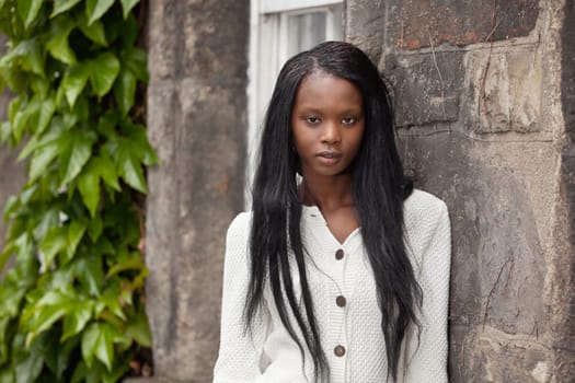 Portrait of African American female standing against stone wall