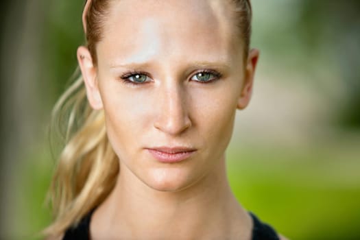 Close-up portrait of young serious woman against blur background