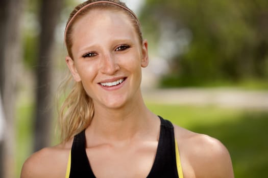 A portrait of a happy female jogger smiling at the camera