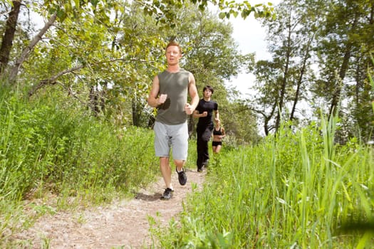 Young friends jogging in the forest  on trail
