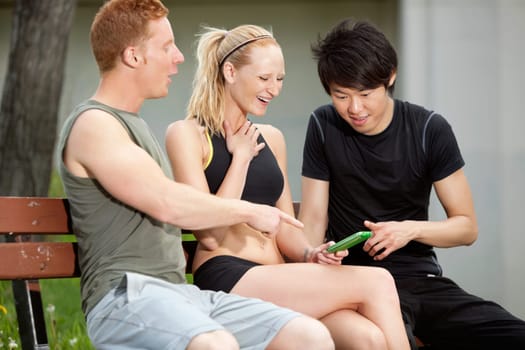 Portrait of three friends playing around with a mobile phone