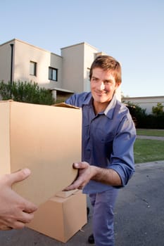 A man passing a moving box to another person