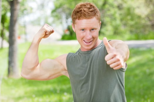 Handsome man showing thumbs up sign while flexing