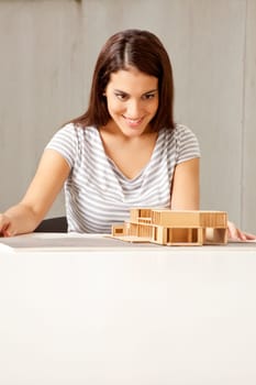A female architect examining a rough model of a house