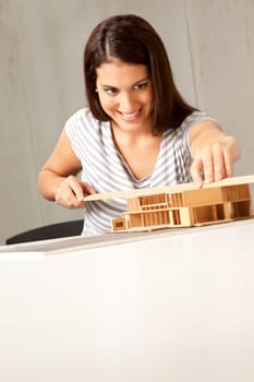 A young architect designing and building a model house