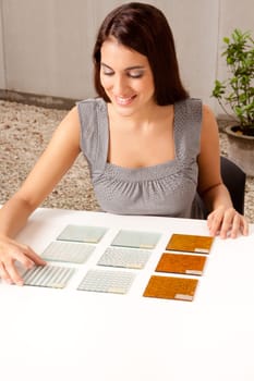 A female architect / designer choosing a glass tile from a group of samples