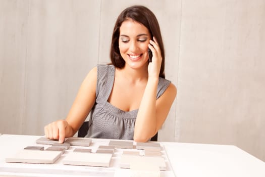 An architect / designer talking on the phone choosing a stone tile