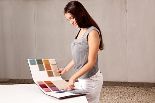 A female interior architect or designer looking at rug samples from a catalogue