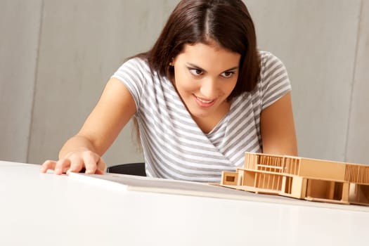 A female architect examining a rough model house