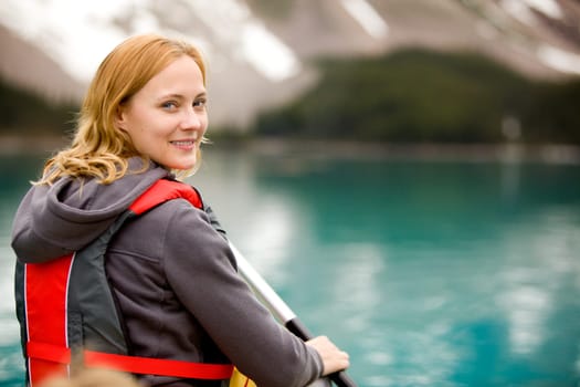 A portrait of a woman on a lake in a canoe