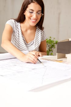 A female architect looking blueprints in an office