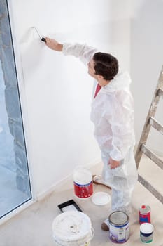 High angle view of workman painting the wall with a roller