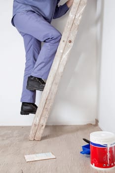 Cropped image of an workman climbing ladder at an apartment