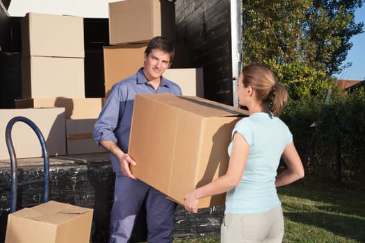 Couple carrying box into the truck while moving into new home