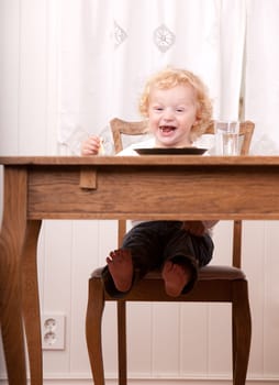 An excited child laughing and looking at the camera with an excited expression