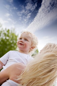 A mother comforting her son in an outdoor setting.