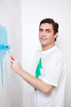 Portrait of smiling man painting his house with roller
