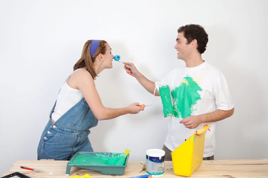 Smiling man painting his wife's nose with paint