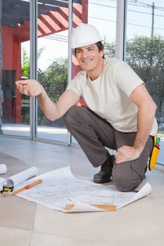 Young construction worker pleased with blueprint