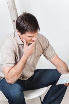 Portrait of young confused man looking at color guide
