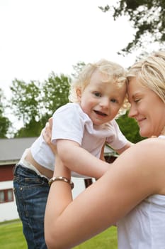 Smiling young mother holding her adorable baby
