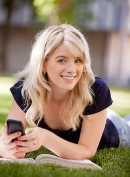 Portrait of an attractive university student sending a text message on a cell phone