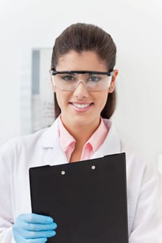 Smiling confident young dentist holding clipboard