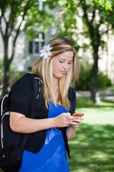 Pretty college girl busy texting on cell