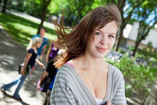 Portrait of a sweet college girl with friends in background