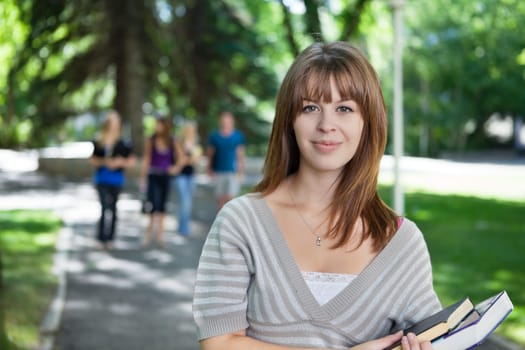 Portrait of young girl smiling while her classmates walking in the background