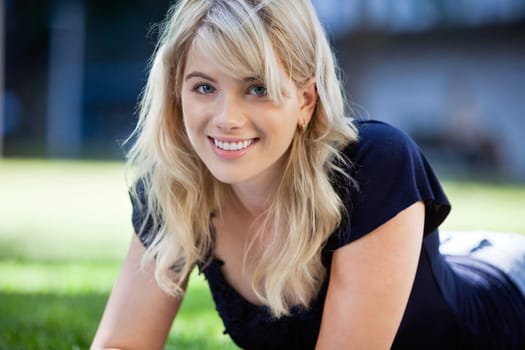 Portrait of pretty young girl lying on grass
