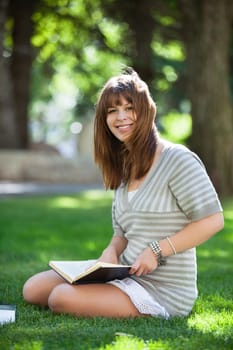 Portrait of college student sitting on campus lawn