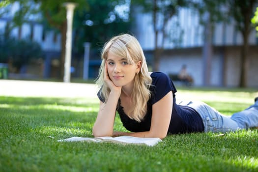 Portrait of beautiful relaxed young female student with a book