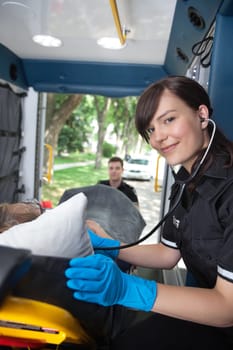 Portrait of EMT professional listening to heart rate of senior patient