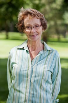 Close-up portrait of happy senior woman standing in park
