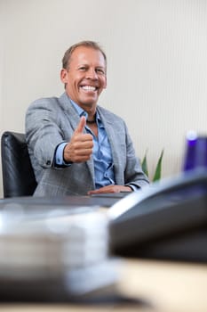 Happy smiling businessman with thumbs up gesture