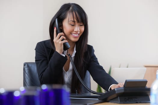 Young smiling business woman talking on phone