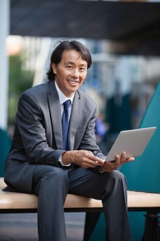 Portrait of an Asian businessman using laptop
