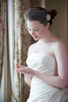 pretty bride in wedding dress looking at her wedding ring
