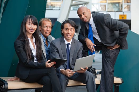 Portrait of smiling business people using electronic gadgets