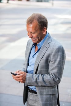 Portrait of happy businessman text messaging
