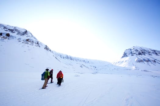 A group of people treking across a winter landscape
