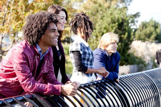 A group of friends outside in a park having fun - shallow depth of field with sharp focus on first person