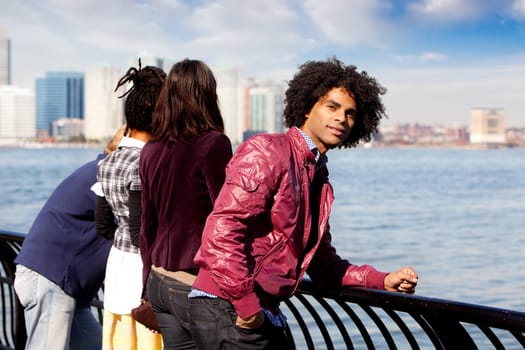 An African American looking at the camera with a group of friends in the background