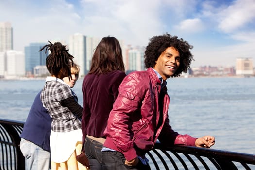 An African American looking at the camera with a group of friends in the background