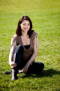 A pretty female isolated on a background of grass in a park