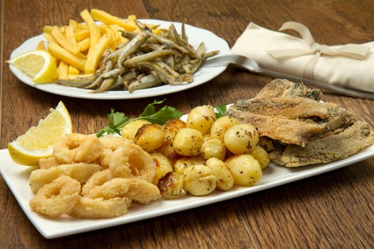a dish with different fish fried and potate