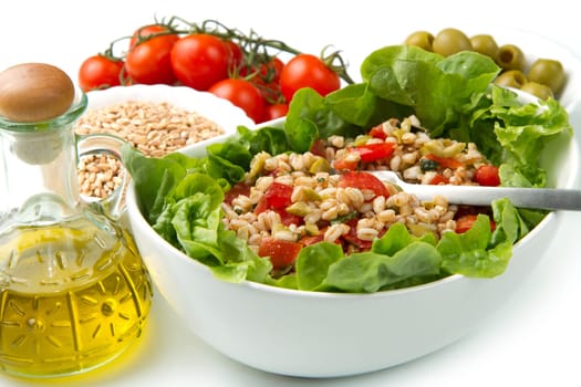 a dish with spelt salad with tomatoes,olive and salad