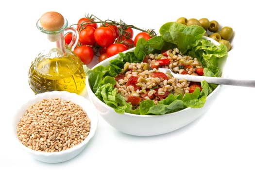 a dish with spelt salad with tomatoes,olive and salad